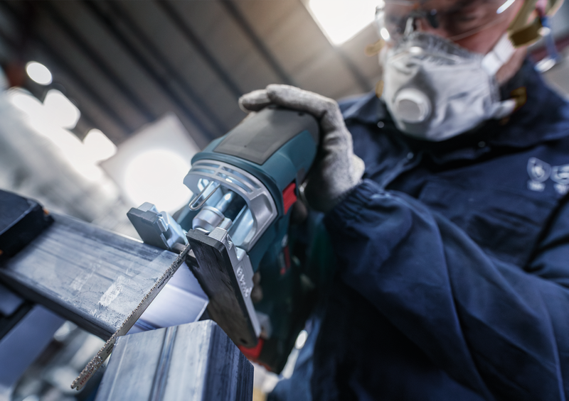 Worker using Bosch jigsaw with T321BF blade to cut metal profile, showing industrial use and blade efficiency in action.