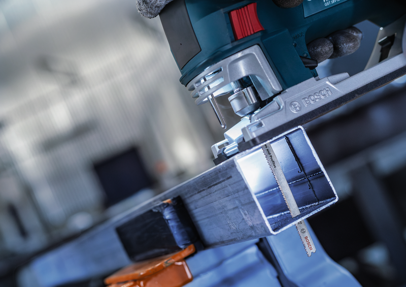 Bosch jigsaw equipped with T321BF blade cutting a square metal tube, emphasizing blade performance on metal profiles.