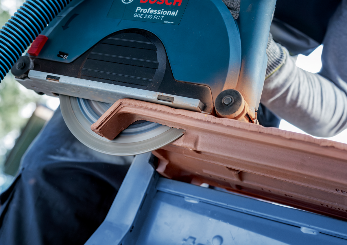 High-speed cutting of tile using Bosch EXPERT MultiMaterial Diamond Cutting Disc 230mm with dust extraction system.