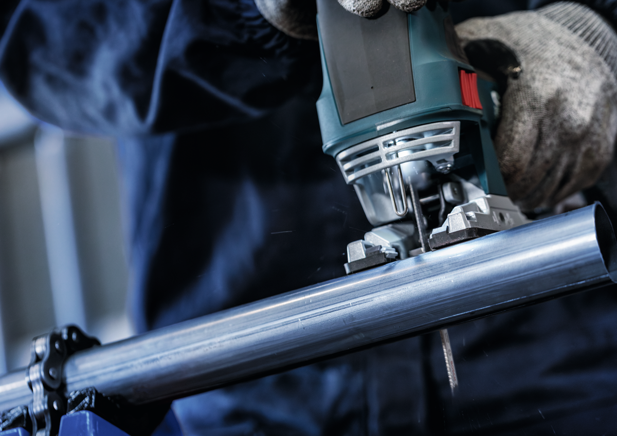 Bosch jigsaw with T321BF blade cutting a round metal pipe, demonstrating versatility in cutting different metal shapes.