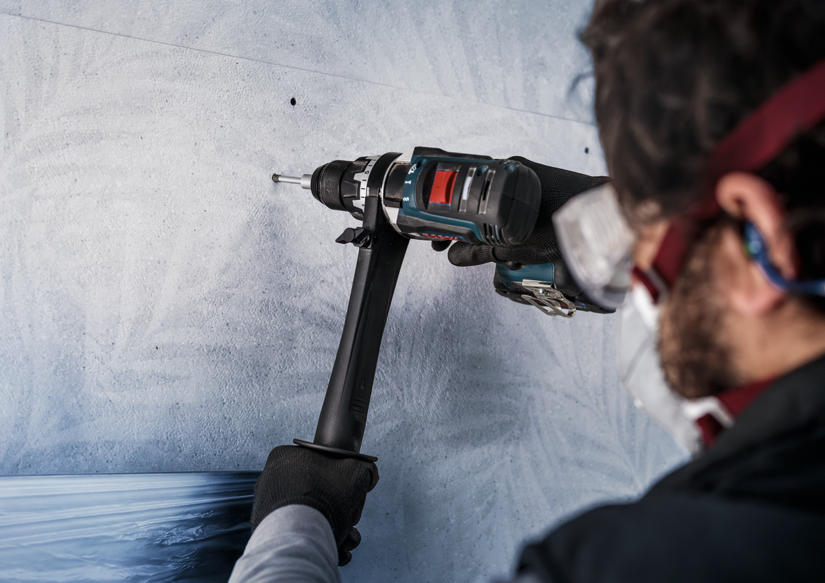 Worker drilling ceramic wall using Bosch PRO Ceramic dry Drill Bit, highlighting ergonomic use and dust-free dry drilling performance.