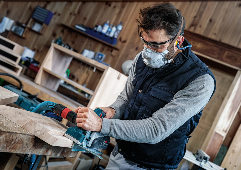 Craftsman operating power planer fitted with Bosch PRO Planer Knife, 82 x 29 x 3 mm 2608635905, shaping wood in a professional workshop.