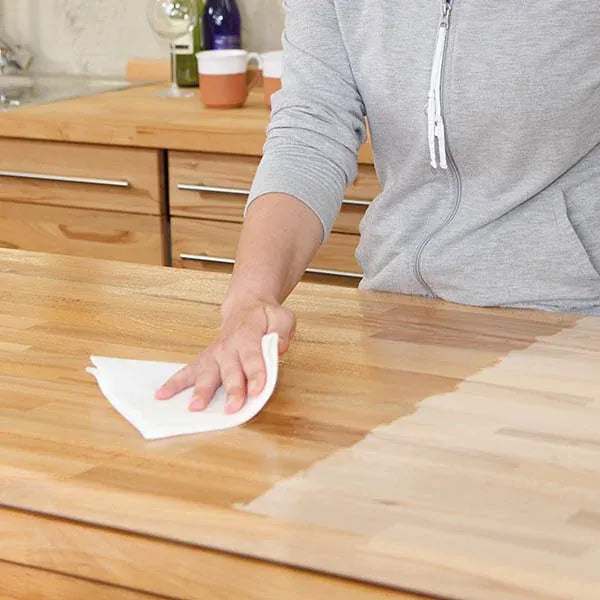Wiping Osmo Top-Oil onto a wooden kitchen worktop with a lint-free cloth